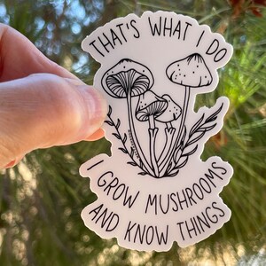 A premium 3 inch by 2 inch die-cut vinyl sticker. The sticker graphic is a black and white cluster of mushrooms with black text. The text says That's What I Do. I Grow Mushrooms And Know Things. Our stickers are waterproof/UV resistant.