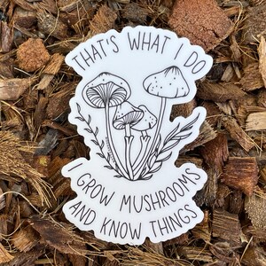 A premium 3 inch by 2 inch die-cut vinyl sticker. The sticker graphic is a black and white cluster of mushrooms with black text. The text says That's What I Do. I Grow Mushrooms And Know Things. Our stickers are waterproof/UV resistant.