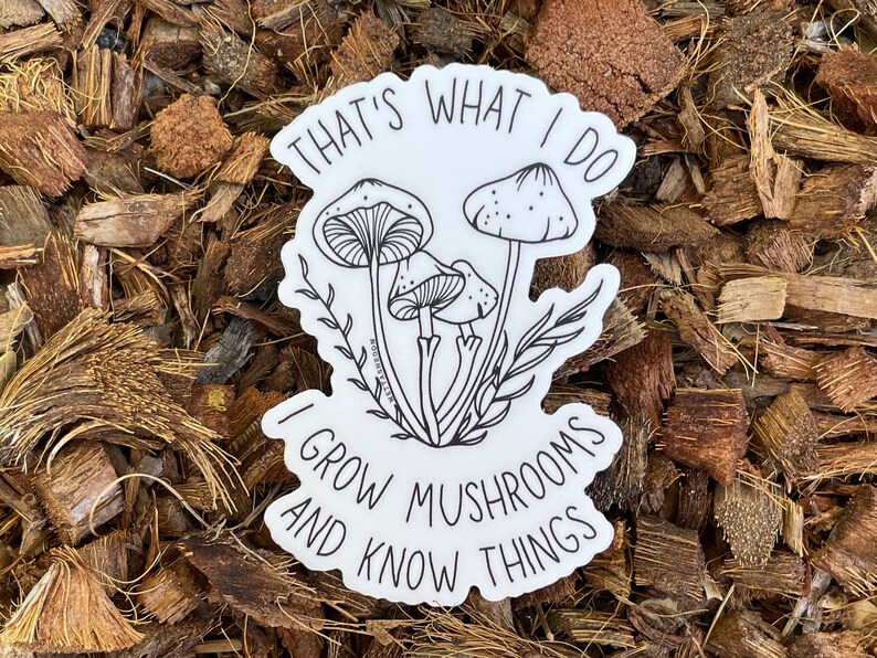 A premium 3 inch by 2 inch die-cut vinyl sticker. The sticker graphic is a black and white cluster of mushrooms with black text. The text says That's What I Do. I Grow Mushrooms And Know Things. Our stickers are waterproof/UV resistant.