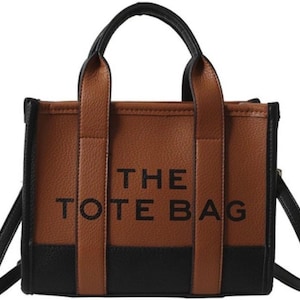 May include: A brown and black tote bag with the text "THE TOTE BAG" printed on the front.