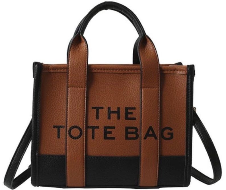 May include: A brown and black tote bag with the text "THE TOTE BAG" printed on the front.