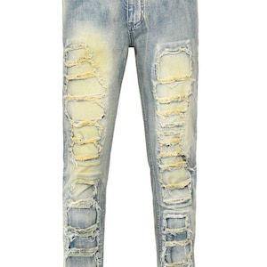 May include: Light blue distressed denim jeans with multiple rips and frayed edges. The jeans have a faded yellow wash.