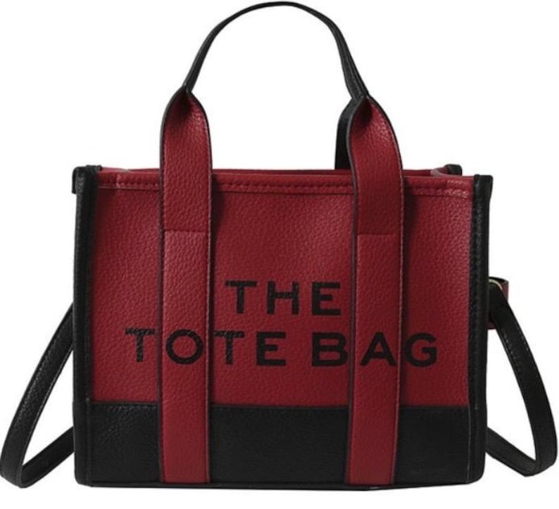 May include: A red and black tote bag with the text "THE TOTE BAG" printed on the front.