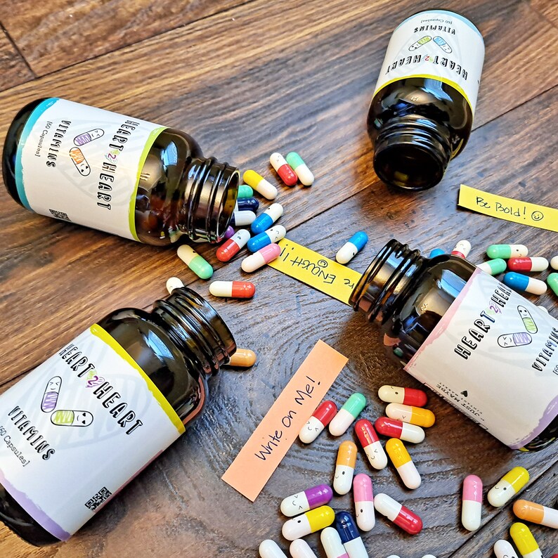 May include: Three bottles of heart-shaped vitamins with labels that say "Heart 2 Heart Vitamins" and a variety of colorful heart-shaped pills scattered around them.  The labels on the bottles also have the text "Be Bold!" "Enough!!" and "Write on Me!"