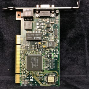 May include: A green circuit board with a variety of electronic components, including a large integrated circuit chip with the text "85H9533 (88H3227) IBM98 52 1972843665 JAPAN" printed on it. The board also has a connector for a VGA monitor and a connector for a network cable. The text "FCC ID: ANO41H8862" is printed on the board.