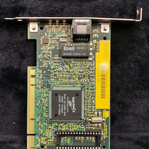 Puede incluir: Una placa de circuito impreso verde con una pegatina amarilla que dice "Parallel Tasking II Performance 3Com 40-0483-004 00487 77141557 LUCENT 40-04834". La placa tiene un chip que dice "#bel 004351A S558-5999-46".