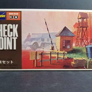 May include: A model kit box featuring a "Checkpoint" scene. The artwork shows a military checkpoint with a truck, guard tower, and small buildings. The text "CHECK POINT" is clearly visible.
