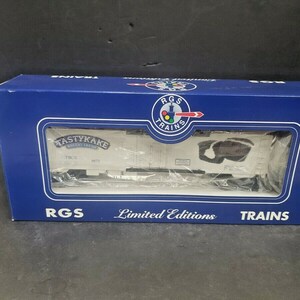 Puede incluir: Una caja azul con un logotipo de RGS Trains blanco y rojo. La caja presenta un vagón de tren modelo blanco con las palabras "Tastykake Bakery Fresh" impresas en el lateral. La caja también dice "Ediciones Limitadas" en la parte delantera.