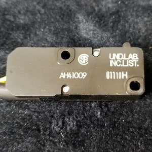 May include: A black electrical switch with the text "UNDLAB INC.LIST." and "AH41009 01110H" printed on it.