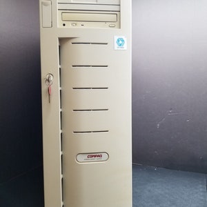 Peut inclure: Un serveur Compaq Proliant 1500 beige avec une clé dans la serrure et un autocollant bleu avec le texte "0118033".
