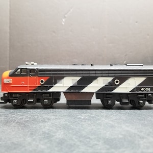 May include: Black and white toy train engine with red accents and the number 4008 on the side.