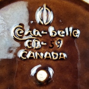 Puede incluir: Primer plano de un plato de cerámica marrón con un logotipo blanco que dice "Cra-belle Co. 59 CANADA".