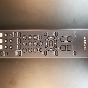 Könnte beinhalten: Schwarze Fernbedienung für einen Sony Fernseher mit Tasten für Strom, Lautstärke, Kanal, Menü, Guide, Sleep, MTS/SAP, Display und Zifferntasten. Die Fernbedienung trägt den Schriftzug "SONY TV" auf der Vorderseite.