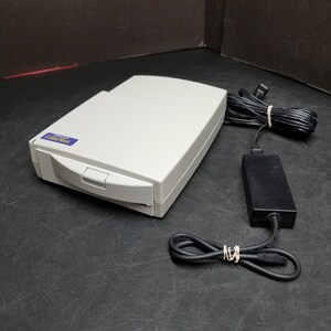 May include: A white Canon ColorShot scanner with a blue label and a black power adapter and cord.