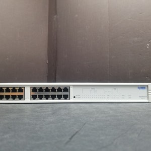 May include: A white 16-port network hub with the text "3Com" and "HUB-07" printed on the front. The hub has a row of lights on the front.