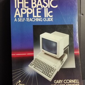 Puede incluir: Un libro titulado "The Basic Apple IIc: A Self-Teaching Guide" de Gary Cornell y William Abikoff. La portada presenta una computadora Apple IIc blanca con un teclado blanco y negro y un monitor.