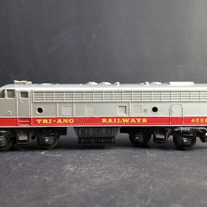 May include: A silver and red toy train engine with the words "TRI-ANG RAILWAYS" and "4008" printed on the side.