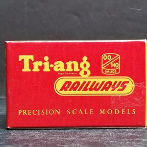 Puede incluir: Una caja roja con las palabras "Tri-ang Railways" en letras amarillas. La caja también tiene un círculo amarillo con las palabras "OO HO Gauge" dentro. La caja dice "Precision Scale Models" en letras amarillas.