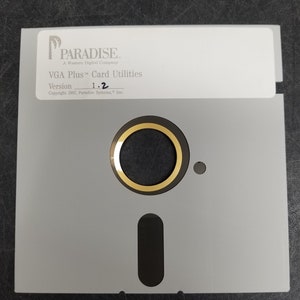 May include: A gray floppy disk with a black label. The label has the text "PARADISE. A Western Digital Company VGA Plus™ Card Utilities Version 1.2 Copyright 1987, Paradise Systems, Inc."