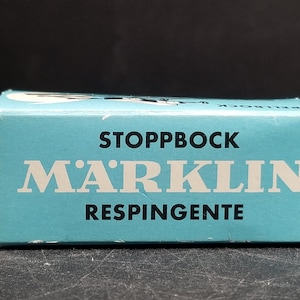 May include: A blue box with white text that reads "STOPPBOCK MARKLIN RESPINGENTE".
