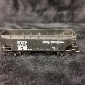 May include: Black model train car with white lettering that reads "NKP 84373" and "Nickel Plate Road".