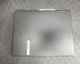Puede incluir: Un portátil Compaq Armada negro con una pegatina roja de Compaq en la parte delantera.