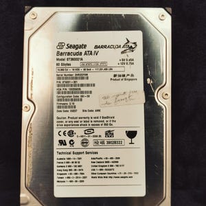 May include: A silver Seagate Barracuda ATA IV hard drive with the model number ST360021A and 60 GB of storage. The drive has a sticker with technical support information and a warning about voiding the warranty if the SeaShield cover is removed.