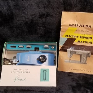 Op de afbeelding: Een blauwe en witte elektrische knoopsgatnaaimachine met gebruiksaanwijzing en onderhoudsinstructies. De machine zit in de originele doos en heeft een groene afwerking. De instructies bevatten de tekst "ELECTRIC SEWING MACHINE" en "new streamlind design".