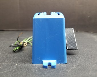 Könnte beinhalten: Ein blaues Kunststoff-Elektroteil mit einem schwarzen rechteckigen Schalter und einem Satz Drähte.