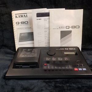 May include: A black Kawai Q-80 digital MIDI sequencer with a floppy disk drive, a large knob, and a digital display. The sequencer is accompanied by three instruction manuals.