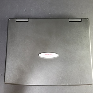 May include: A black laptop computer with a silver Compaq logo on the lid.