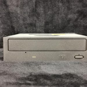 May include: A silver-colored external CD-ROM drive with a black button and the text "Compact Disc" printed on the front.
