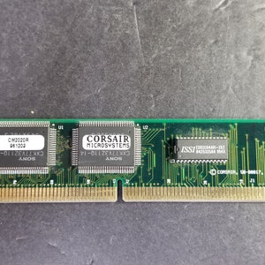 May include: A green circuit board with three integrated circuits. The chips are labeled "CM2020R 961202", "CORSAIR MICROSYSTEMS CXK77V32110-14 ANOS", and "ISSI 842532144 9543".