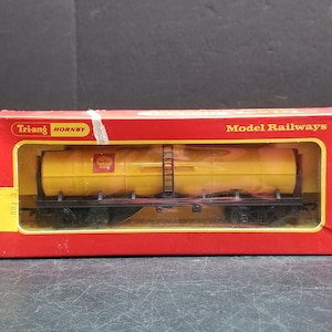 May include: A yellow Triang Hornby Model Railways Shell Tanker Wagon in its original box. The box is red with white lettering and the date 2016-11-30.