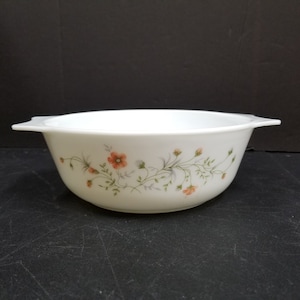 May include: White ceramic baking dish with a floral design featuring small orange flowers and green leaves.