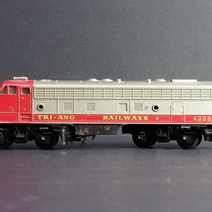 May include: A red and grey toy train engine with the words "TRI-ANG RAILWAYS" and the number "4008" printed on the side.