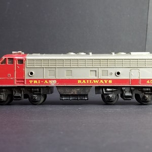 May include: A red and silver toy train engine with the words "TRI-ANG RAILWAYS" and "4068" printed on the side.
