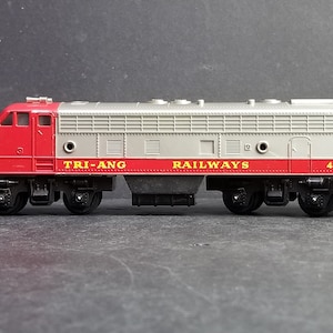 May include: A red and grey toy train engine with the words "TRI-ANG RAILWAYS" and "4008" printed on the side.