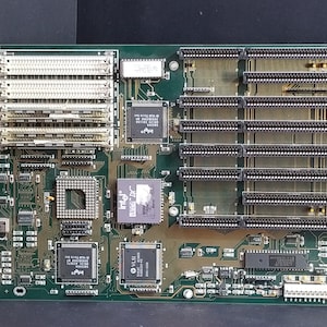 May include: A green circuit board with multiple chips and connectors. The board has a label that reads "386L REV. 11.1".