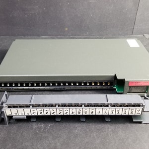 Puede incluir: Un dispositivo electrónico gris con una placa de circuito verde y una fila de conectores. El dispositivo tiene una etiqueta que dice "HEBE 2-MX". También se muestra un componente gris separado con una fila de conectores etiquetados "Pe1" a "Sw3".