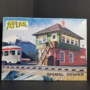 May include: A vintage box for a model train signal tower. The box features a colourful illustration of a train, a mountain, and a signal tower with the text "SIGNAL TOWER" and "HILLSIDE JUNCTION". The box is labelled "ATLAS" and "DEARBORN  FUSE".