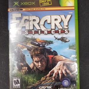 Op de afbeelding: Xbox-gamecase voor Far Cry Instincts, met een groene achtergrond, de titel van het spel in wit en een man die een geweer vasthoudt in een jungle-omgeving. De game is door de ESRB met M voor Mature beoordeeld.
