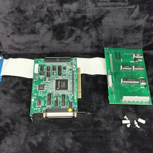 May include: Two green circuit boards with various electronic components, a white ribbon cable connecting them, and four white plastic standoffs.