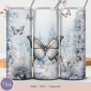May include: A white tapered tumbler with a winter scene featuring a silver glitter butterfly and snow-covered trees. The background is a soft blue with white glitter accents.