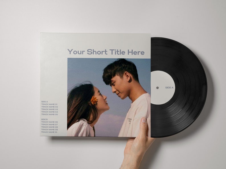 May include: A black vinyl record with a white label that says "Side A". The record is being held in a hand. The record cover is white with a light blue and pink image of a couple looking at each other. The text "Your Short Title Here" is printed in black on the cover. The cover also lists track names for both Side A and Side B.