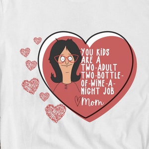 K&ouml;nnte beinhalten: Wei&szlig;es T-Shirt mit einem roten Herz-Grafik, das eine Cartoon-Frau und den Text "YOU KIDS ARE A TWO-ADULT TWO-BOTTLE-OF-WINE-A-NIGHT JOB Mom" zeigt. Das Shirt wird mit schwarzen Turnschuhen und einem Smartphone kombiniert.