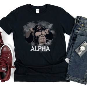 May include: Black t-shirt with a graphic of a gorilla with the word "ALPHA" printed below it.