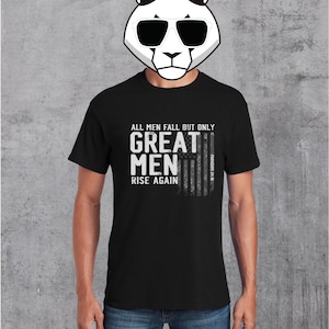 Puede incluir: Camiseta negra con un estampado gr&aacute;fico blanco de una bandera estadounidense con el texto "All men fall but only great men rise again" y la referencia b&iacute;blica "Proverbs 24:16".