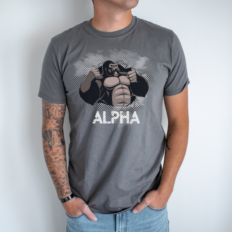 May include: A gray t-shirt with a graphic of a gorilla breaking through a wall with the word "ALPHA" printed below.