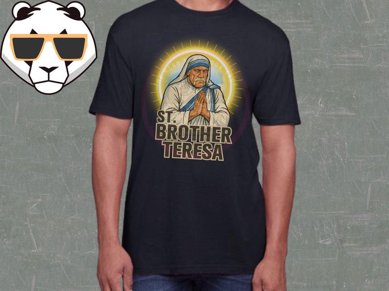 May include: Navy blue t-shirt featuring an illustration of Mother Teresa with the text "ST. BROTHER TERESA". The graphic shows Mother Teresa with her hands clasped in prayer, surrounded by a golden halo.